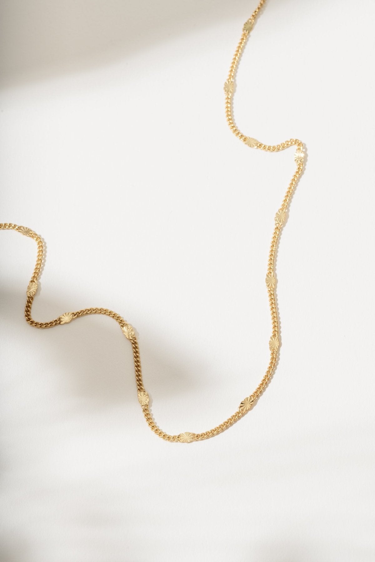 Gold necklace on a light background