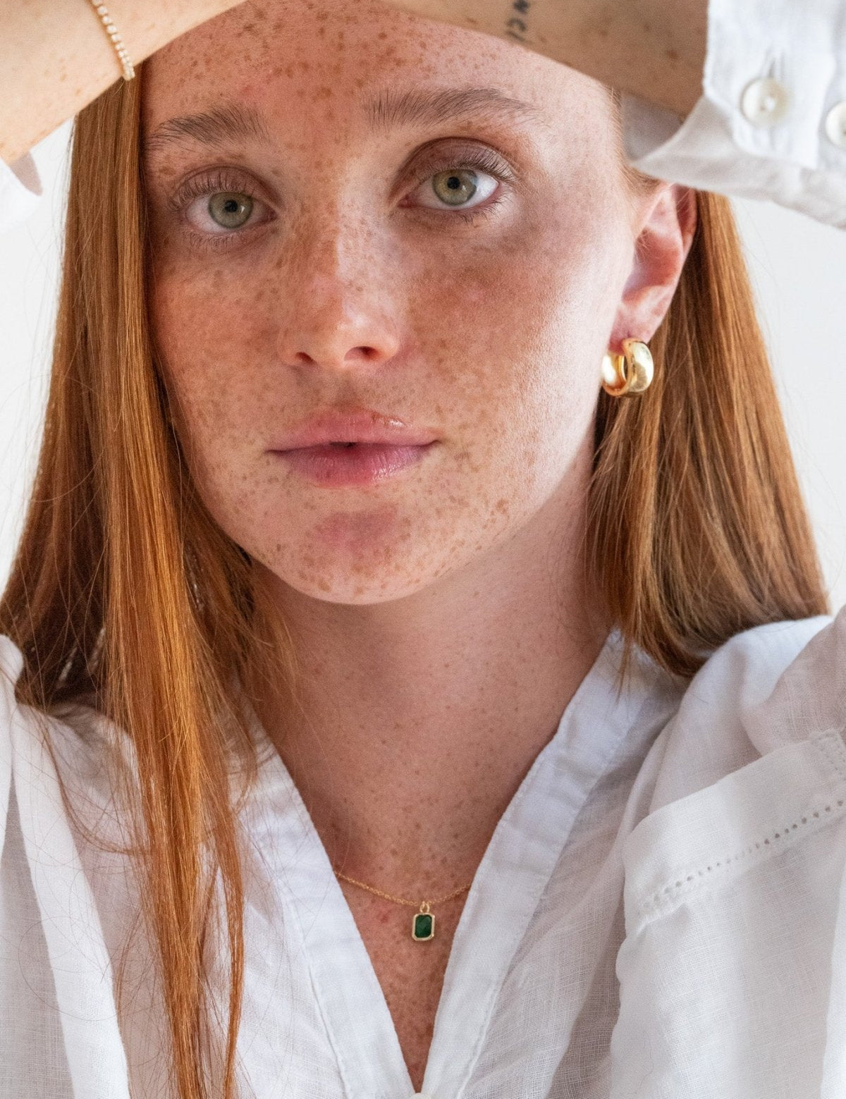 Person wearing a white shirt with a plain background