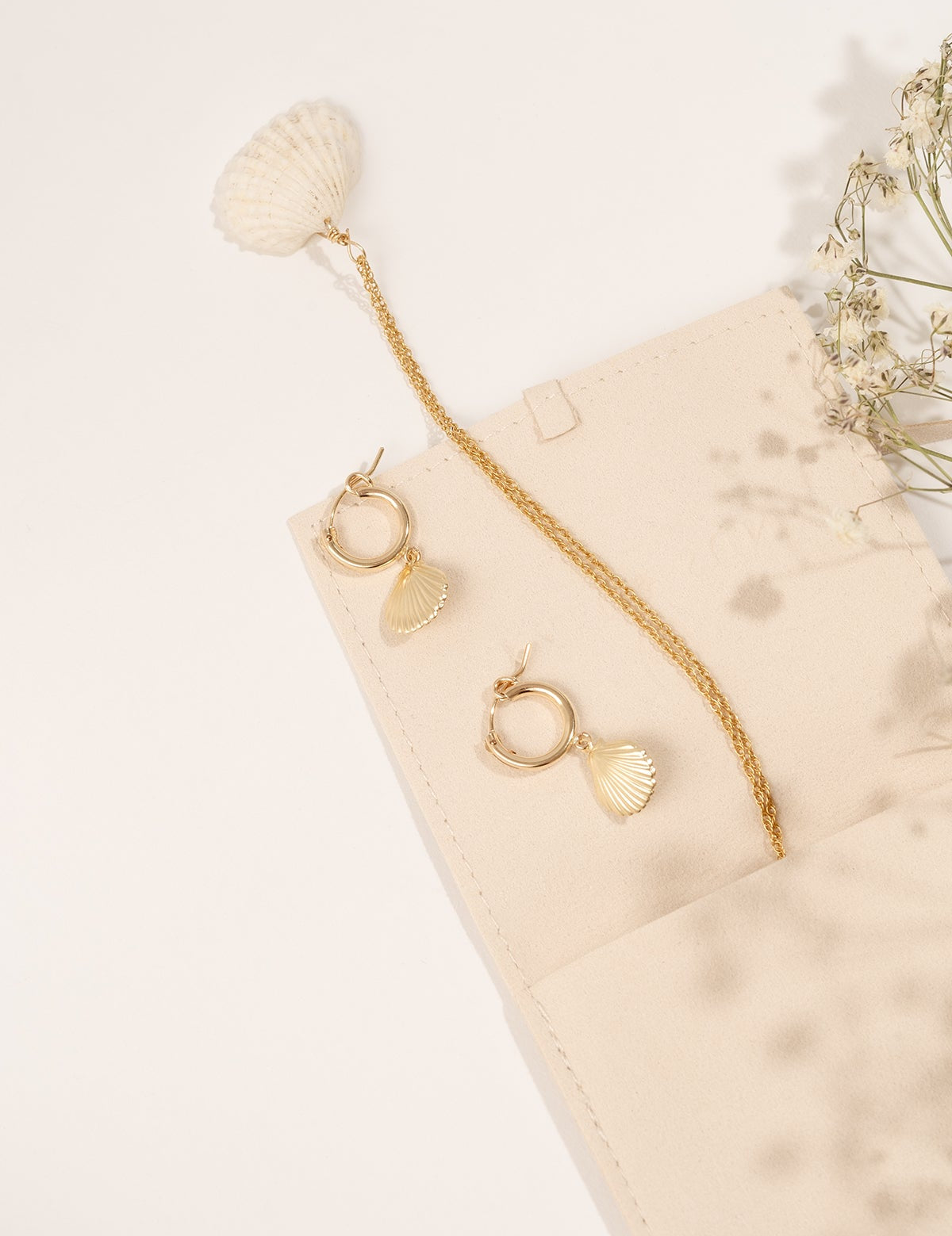 Close-up of the Alana Necklace highlighting its seashell pendant and gold chain.