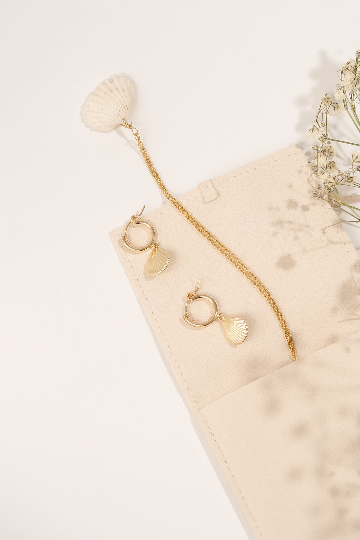 Close-up of the Alana Necklace highlighting its seashell pendant and gold chain.