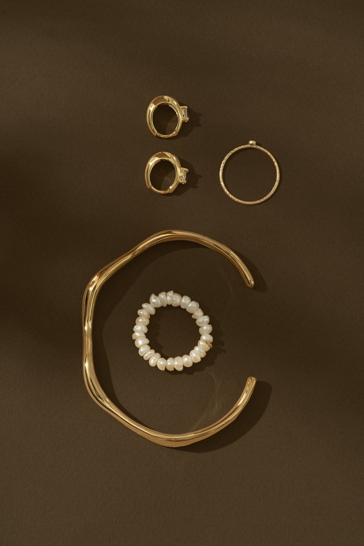 gold jewelry on brown background
