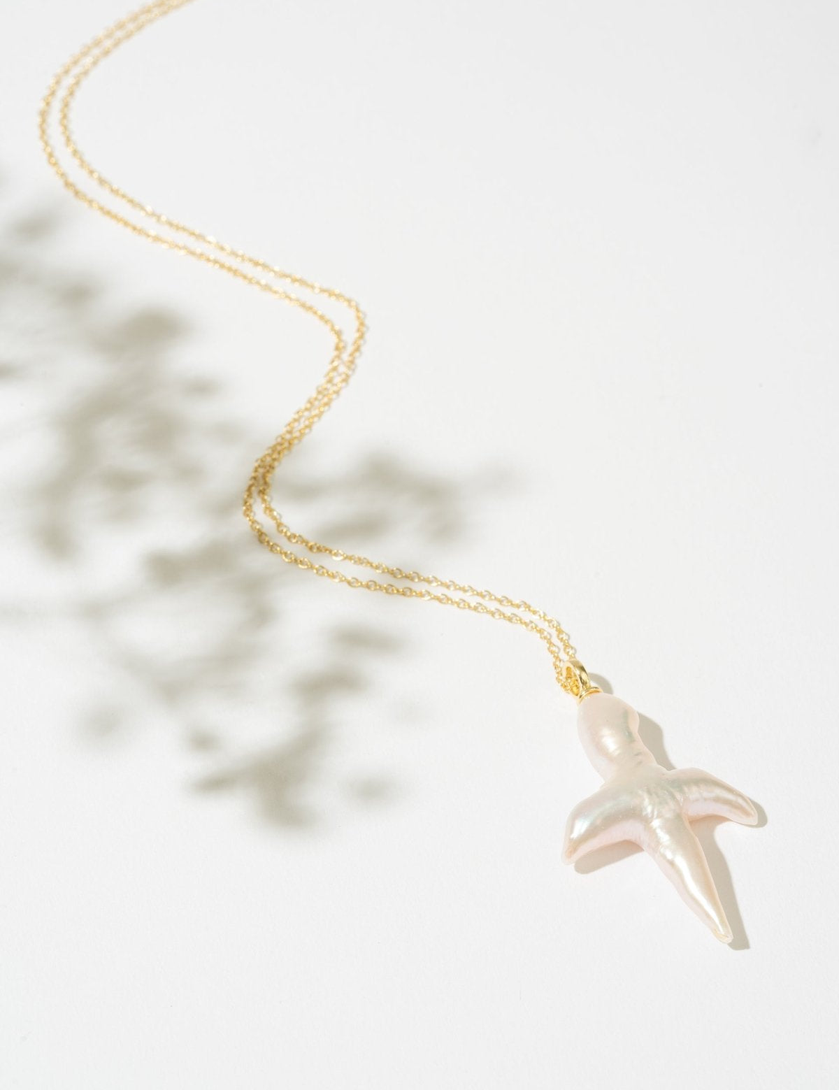 Gold necklace with a pearl cross pendant