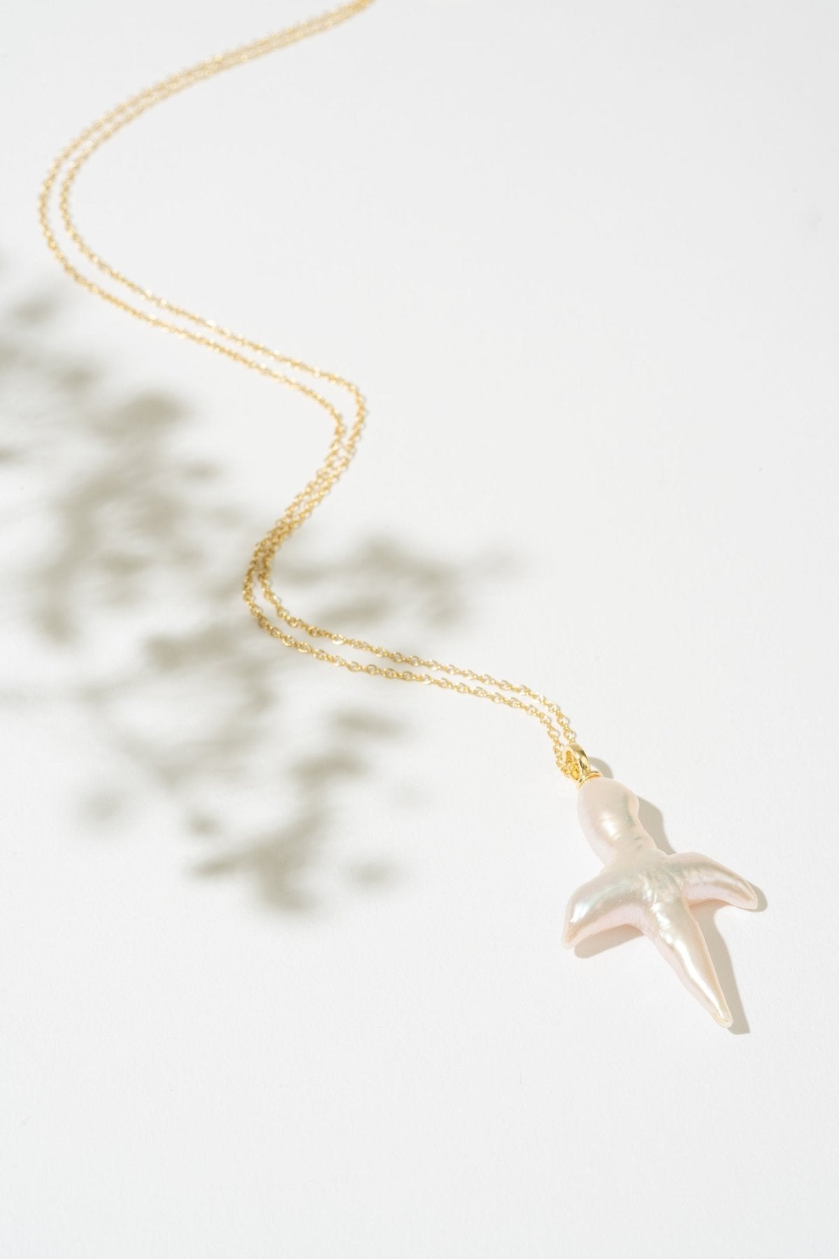 Gold necklace with a pearl cross pendant