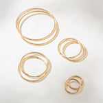 Set of gold hoop earrings on a light gray background