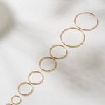 Set of gold hoop earrings on a light background